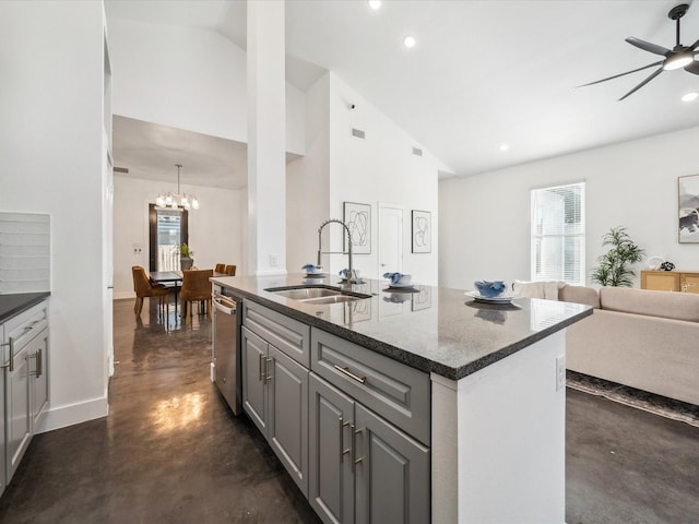 kitchen with sink, gray cabinetry, ceiling fan with notable chandelier, a kitchen island with sink, and lofted ceiling