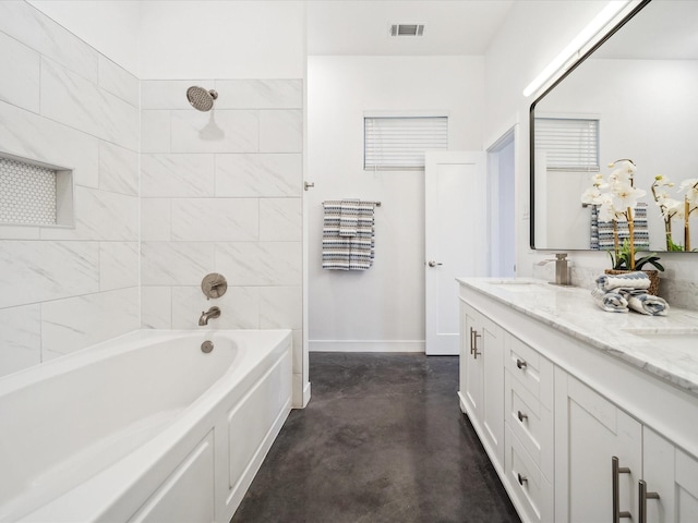 bathroom featuring tiled shower / bath combo, vanity, and concrete flooring