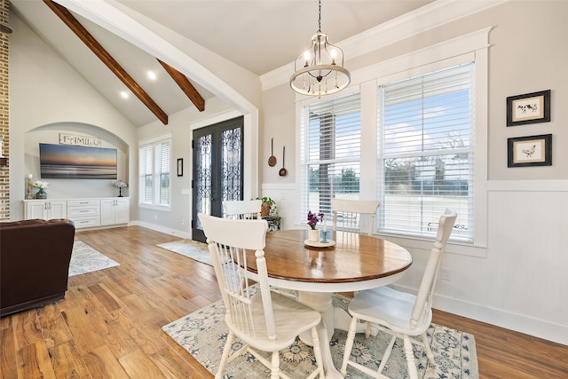 dining room featuring an inviting chandelier, plenty of natural light, lofted ceiling with beams, and light hardwood / wood-style flooring