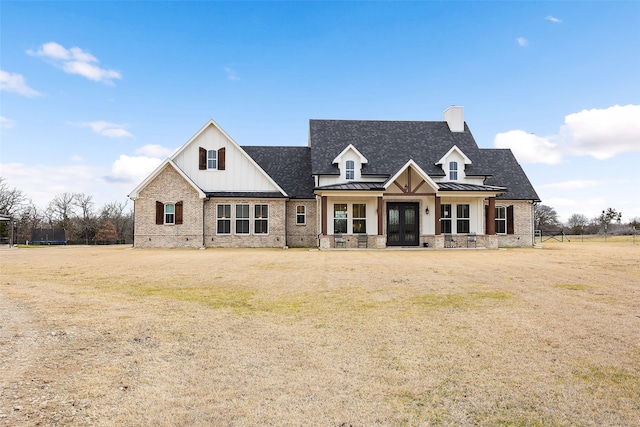 view of front of home with covered porch and a front lawn