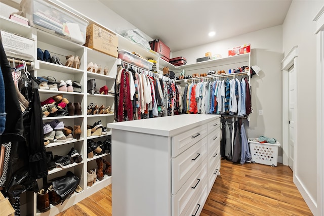 walk in closet with light hardwood / wood-style floors