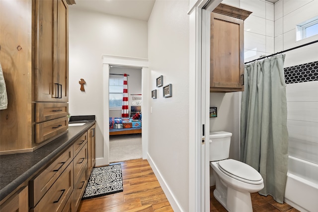 full bathroom with vanity, hardwood / wood-style flooring, shower / bath combination with curtain, and toilet