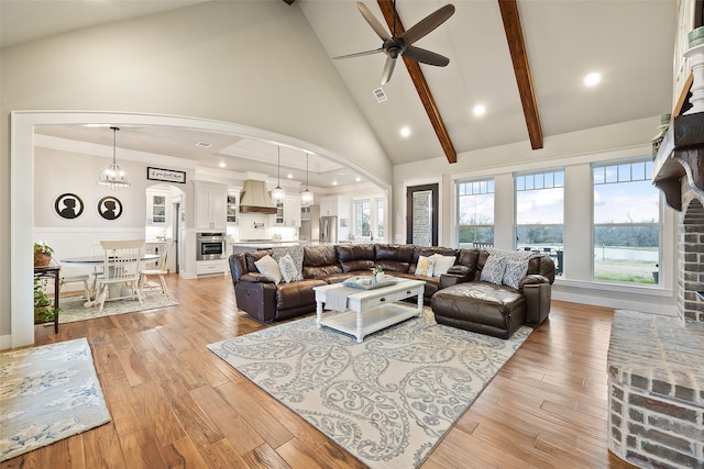 living room with light hardwood / wood-style flooring, high vaulted ceiling, beamed ceiling, and ceiling fan