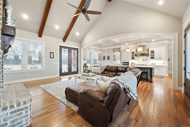 living room with french doors, ceiling fan, high vaulted ceiling, and light hardwood / wood-style flooring