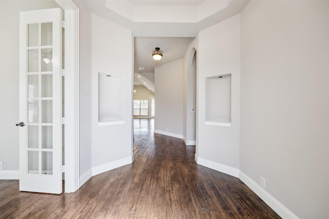 hall featuring baseboards and dark wood-type flooring