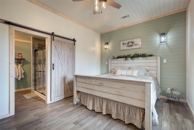 bedroom featuring wood ceiling, ceiling fan, a barn door, and hardwood / wood-style flooring