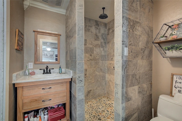 bathroom featuring a shower, toilet, vanity, and ornamental molding