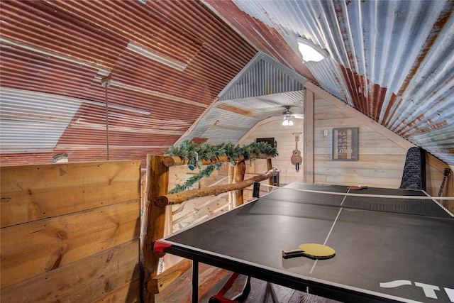 rec room with wood walls and vaulted ceiling