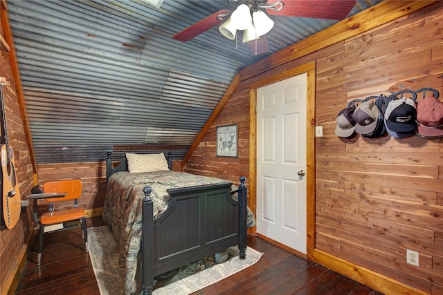 bedroom featuring ceiling fan, wood walls, dark hardwood / wood-style flooring, and lofted ceiling