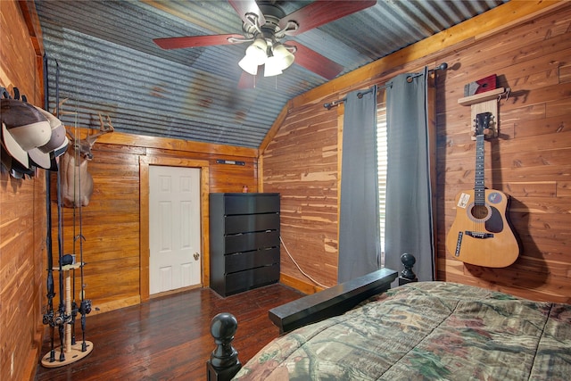 bedroom featuring ceiling fan, wooden walls, dark hardwood / wood-style flooring, and lofted ceiling