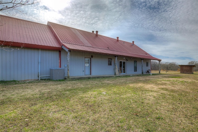 rear view of house with a lawn and central AC