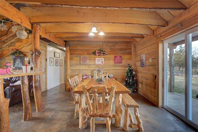 dining space with wood walls and vaulted ceiling with beams