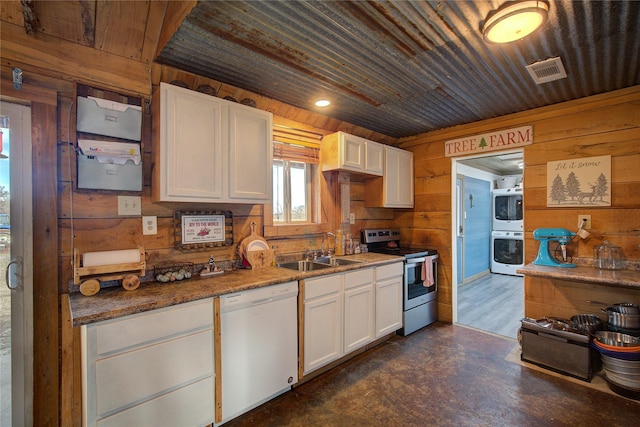 kitchen featuring white dishwasher, stainless steel electric range oven, white cabinetry, sink, and wood walls