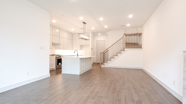 1804 Wittington Pl, Farmers Branch, TX 75234 - unfurnished living room featuring a sink, baseboards, wood finished floors, recessed lighting, and stairway