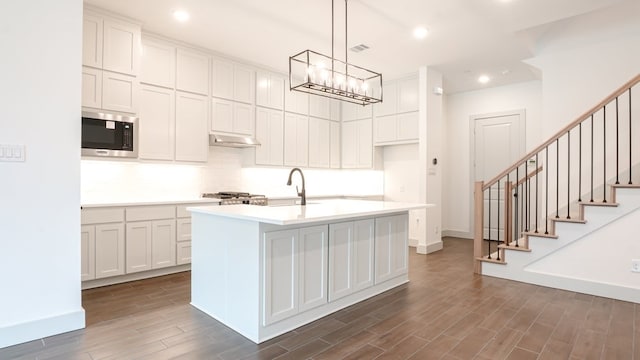 1804 Wittington Pl, Farmers Branch, TX 75234 - kitchen featuring stainless steel microwave, dark wood-style flooring, a sink, decorative backsplash, and light countertops