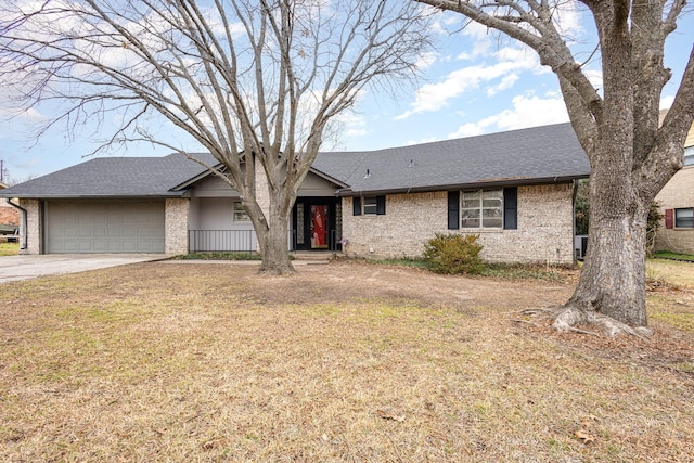 single story home with brick siding, a shingled roof, concrete driveway, an attached garage, and a front yard