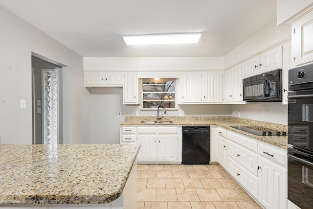 kitchen featuring white cabinetry, a sink, black appliances, and light stone countertops