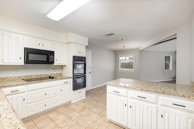 kitchen featuring pendant lighting, white cabinetry, visible vents, and black appliances