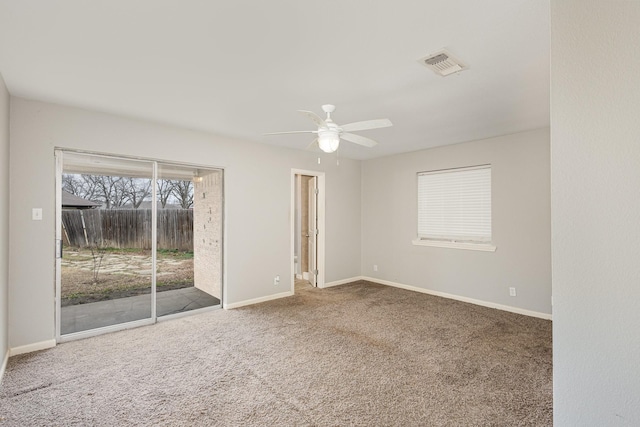 empty room featuring ceiling fan, carpet flooring, visible vents, and baseboards