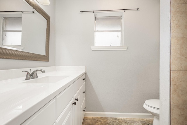 bathroom with vanity, toilet, and baseboards