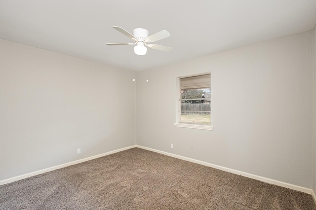 carpeted empty room with a ceiling fan and baseboards