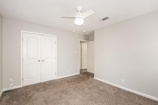 unfurnished bedroom with a closet, carpet flooring, visible vents, and baseboards