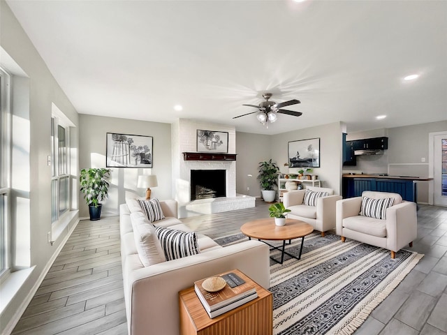 living room featuring ceiling fan and a brick fireplace