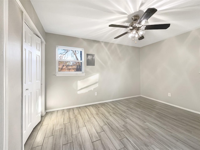 unfurnished bedroom with ceiling fan, a closet, and light wood-type flooring