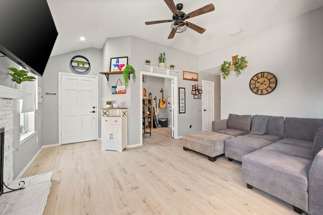 living room with a fireplace, light hardwood / wood-style floors, ceiling fan, and lofted ceiling