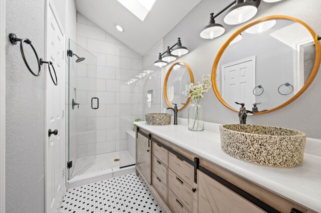 bathroom featuring vanity, walk in shower, and vaulted ceiling with skylight