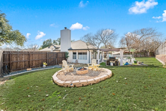 rear view of property with an outdoor fire pit and a yard