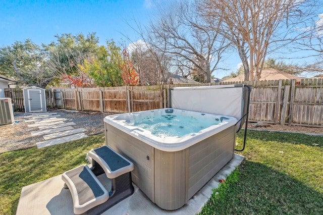 view of yard featuring central air condition unit, a storage shed, and a hot tub