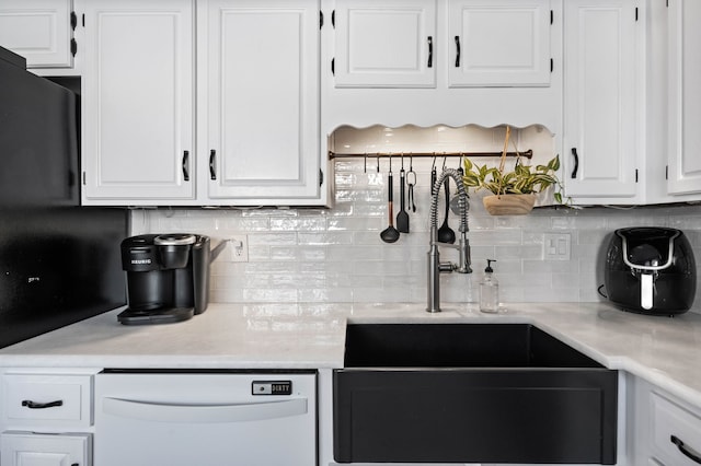 kitchen with white cabinets, dishwasher, and tasteful backsplash