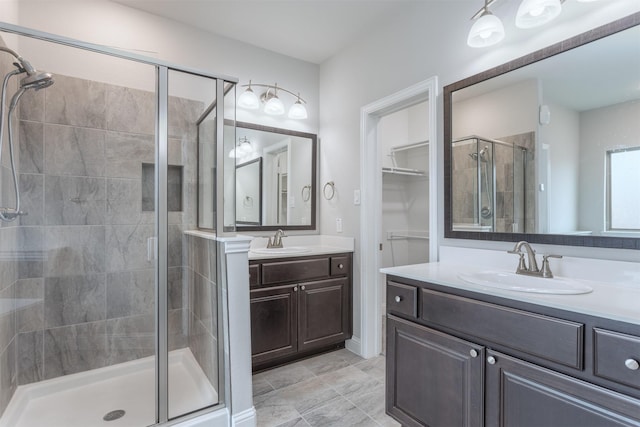 bathroom featuring a shower with door and vanity