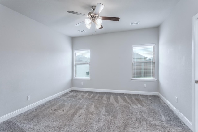 empty room with ceiling fan, carpet flooring, and a wealth of natural light