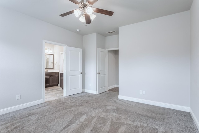 unfurnished bedroom with ceiling fan, connected bathroom, and light carpet