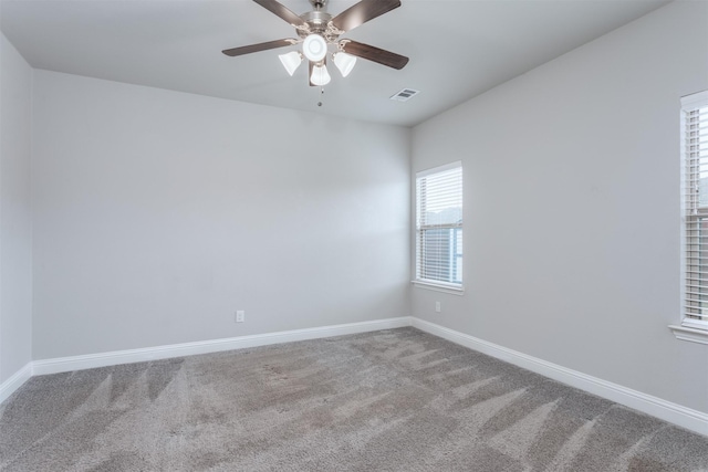 empty room with ceiling fan and carpet