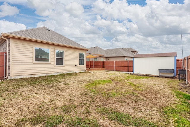 rear view of property with a lawn and a storage shed