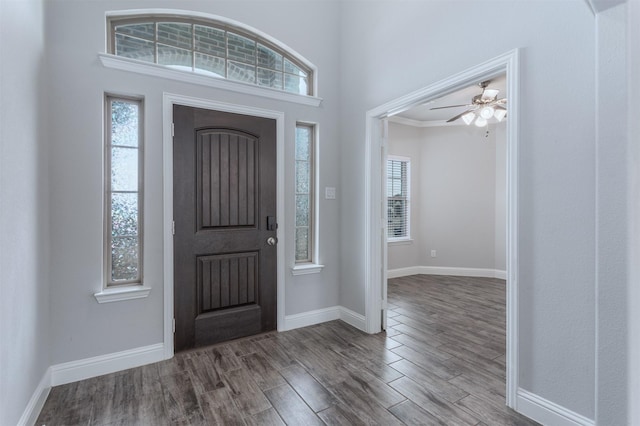 foyer entrance with ceiling fan, a wealth of natural light, and crown molding