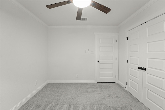 carpeted spare room with crown molding and ceiling fan