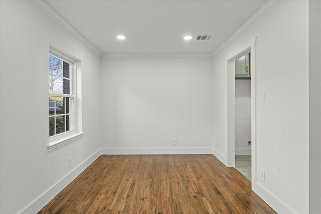 unfurnished room with dark wood-type flooring, crown molding, and plenty of natural light