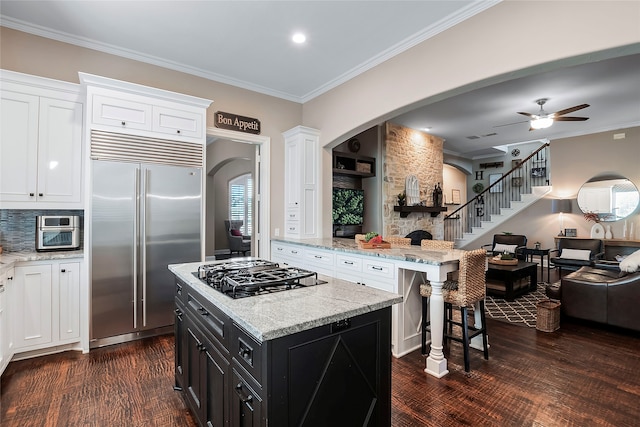 kitchen featuring stainless steel built in fridge, white cabinets, gas stovetop, and a kitchen island