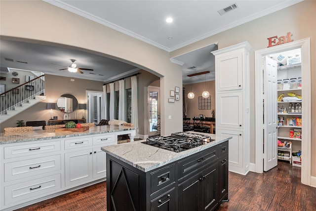 kitchen featuring gas stovetop, white cabinetry, dark hardwood / wood-style floors, and crown molding