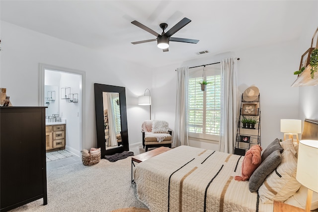 carpeted bedroom with ceiling fan and connected bathroom