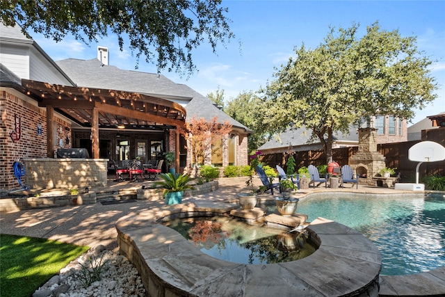 view of pool with a patio area and an outdoor stone fireplace