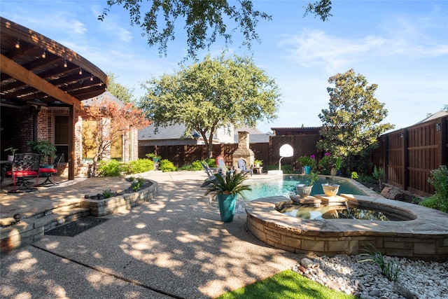 view of patio featuring a swimming pool with hot tub and an outdoor stone fireplace