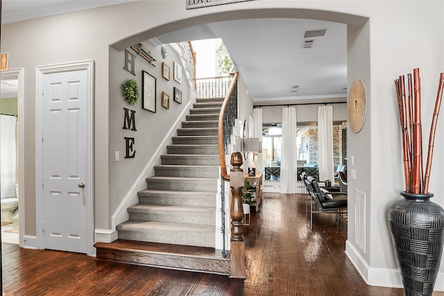 stairs featuring hardwood / wood-style floors and crown molding