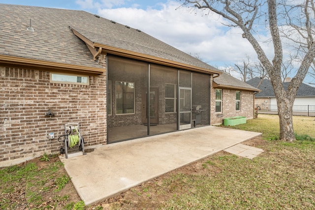 rear view of property featuring a patio area, a lawn, and a sunroom