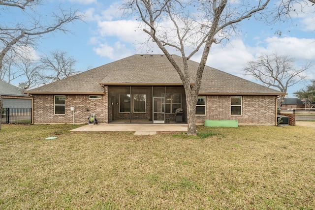 back of property with a patio area, a sunroom, a lawn, and central AC