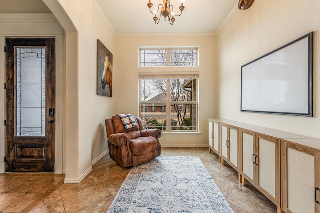 sitting room featuring ornamental molding and an inviting chandelier